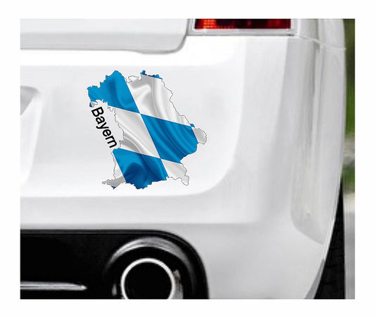 Das Bild zeigt den Umriss des Bundeslandes Bayerns mit blau weißen Karos. Dazu steht über dem Bild der Schriftzug Bayern. Erhältlich ist dieser Artikel mit der Schrift und Umrandung in Weiß oder Schwarz. Man kann auch nur das Abbild Bayerns ohne Schriftzug bzw. Text erhalten.