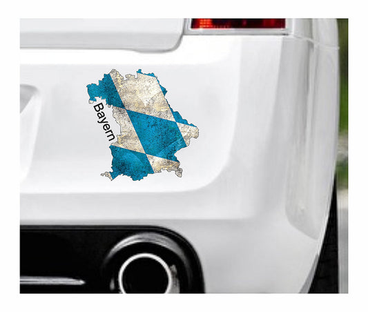 Das Bild zeigt den Umriss des Bundeslandes Bayerns mit blau weißen Karos und einem Herz. Dazu steht über dem Bild der Schriftzug Bayern. Erhältlich ist dieser Artikel mit der Schrift und Umrandung in Weiß oder Schwarz. Man kann auch nur das Abbild Bayerns ohne Schriftzug bzw. Text erhalten.