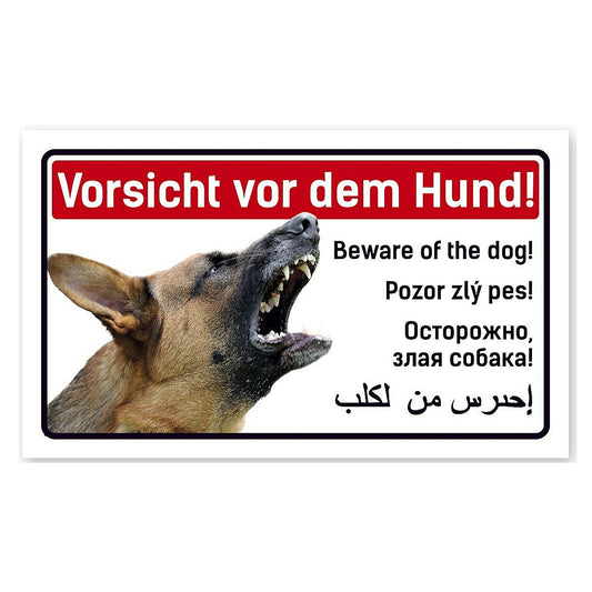 Das Bild zeigt einen bellenden Schäferhund. Dazu steht über und neben dem Bild der Schriftzug "Vorsicht vor dem Hund!" in Deutsch, Englich, Polnisch, Russisch und in Arabisch. 